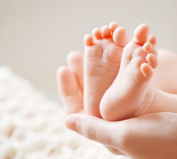 Babyfuesse mit der Ferse in einer Handfläche liegend